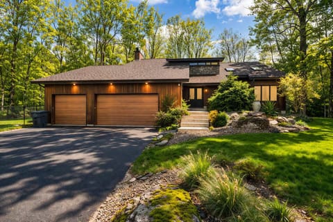 Modern mountain-style exterior with elegant lighting and a spacious driveway.