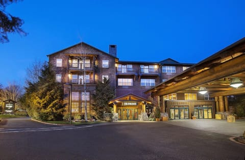 Arrive to a warmly lit lodge entrance at dusk.