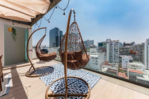 Rooftop setup with swing chairs and panoramic city views.