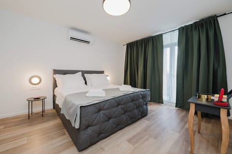Bedroom with a king-size bed, clothing storage, and access to the balcony.