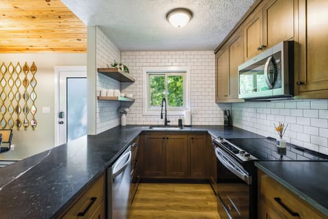 Modern kitchen with sleek counters & wood cabinets—perfect for cooking & sharing