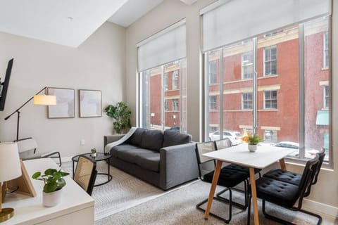 Spacious open-concept living and dining area featuring a vibrant sofa, modern furnishings, and a stylish entertainment setup—ideal for gatherings and relaxation.