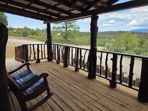 Covered deck framing a wide view of the surrounding forest and mountains.
