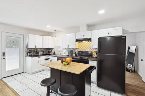Cook with ease in this modern kitchen, featuring high-end appliances, stylish cabinetry, and a convenient island for dining or meal prep
