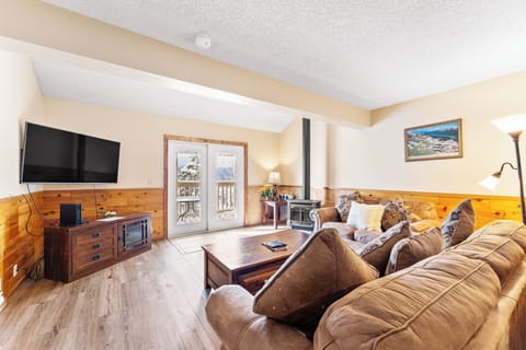 Sink into the plush sectional sofa where you'll unwind after mountain adventures, with cozy wood accents and entertainment ready for your evenings.