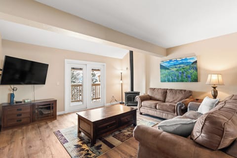 Sink into plush leather sofas by the wood stove, where mountain views through French doors create your perfect après-ski retreat.