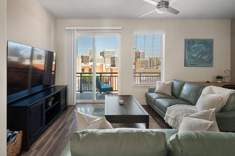 Beautifully designed living room. 75` TV, leather sofa and amazing views of mountains and city skyline.