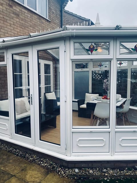 conservatory with dinning and sitting area with garden view