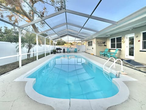 Screened-in pool, a BBQ, cocktail bar area, outdoor furniture, corn hole boards