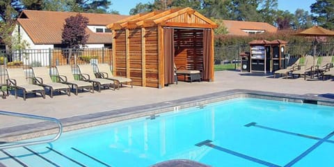 Lounge poolside with shaded cabanas and peaceful open skies.