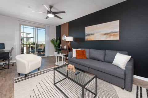 Stylish living room with comfortable sofa bed, working station and private patio.