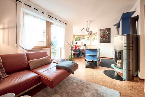 Open living with kitchen, wood stove & comfy couch.