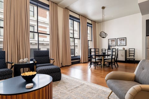 Open living area with high ceilings, floor-to-ceiling windows, and downtown views.