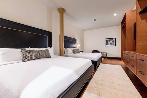 Bedroom 1 - Double king beds featuring a built-in wardrobe, flat-screen TV, additional seating, and en-suite bathroom.