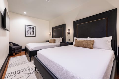 Bedroom 1 - Double queen beds featuring a built-in wardrobe and flat-screen TV.