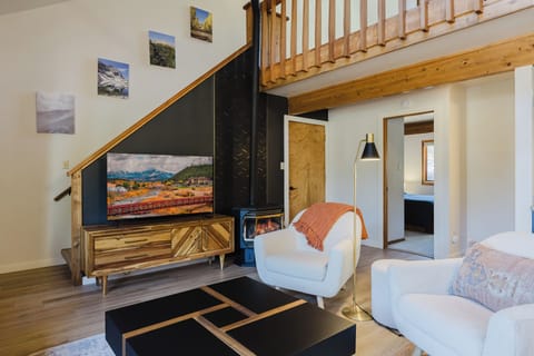 Living Room - The living room features a cozy gas fireplace and a smart TV. This inviting space flows seamlessly into the dining area and fully equipped kitchen.