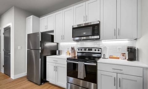 The fully equipped kitchen features sleek, modern appliances and ample counter space, making it easy to prepare your favorite meals or a simple cup of coffee!