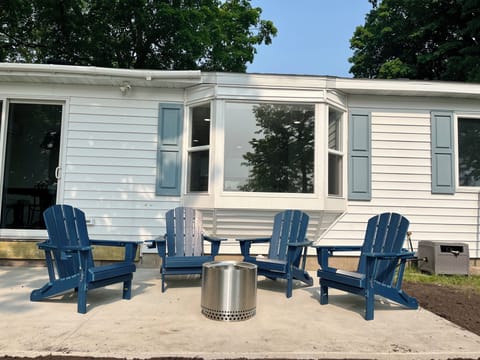 Concrete patio with solo stove fire pit, table + chairs