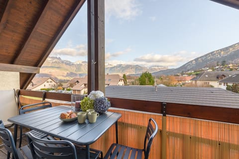 Balcony with deckchairs and dining table offering magnificent mountain views
