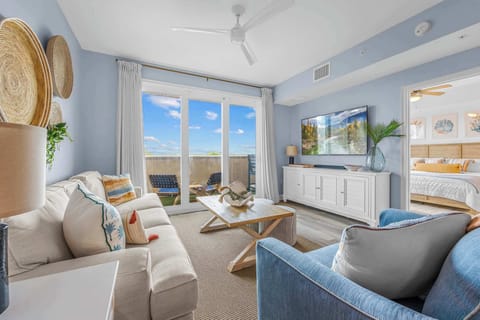 Relax in this coastal-inspired living room with balcony access and natural light.