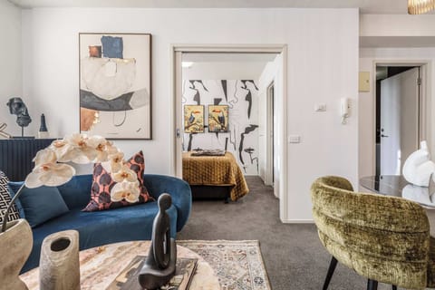 Stylish open-plan living area with modern décor, cozy seating, and a seamless flow into the bedroom for a comfortable stay