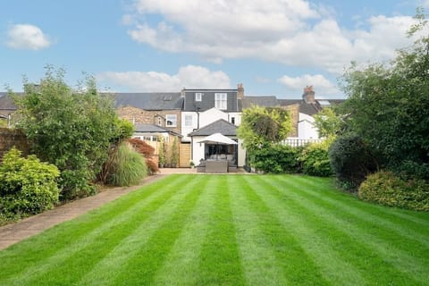 A beautiful, well-maintained lawn (12 x 7 Metres) in an established garden with a path leading from the back of the house down to separate office and TV room.