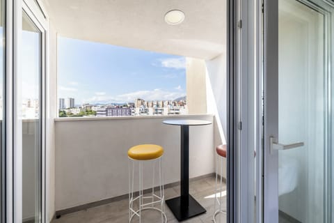 Balcony with a beautiful view of nature and nearby buildings.
