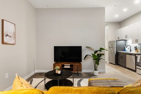 Bright and airy living room with plush seating, a large TV, and tasteful decor, creating the perfect space for relaxation and entertainment.