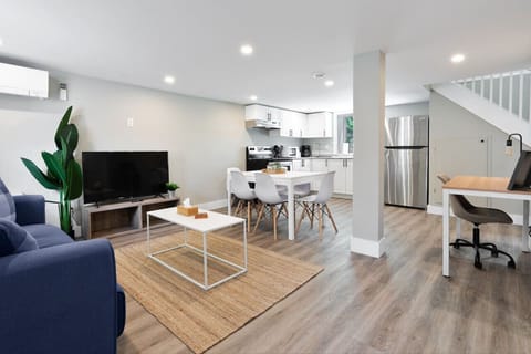 Spacious open-concept living and dining area featuring a vibrant sofa, modern furnishings, and a stylish entertainment setup—ideal for gatherings and relaxation.