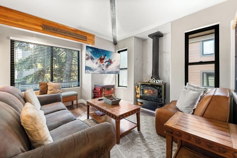 Relax by the wood-burning stove in this inviting living space, complete with comfortable leather seating and a flat-screen TV.