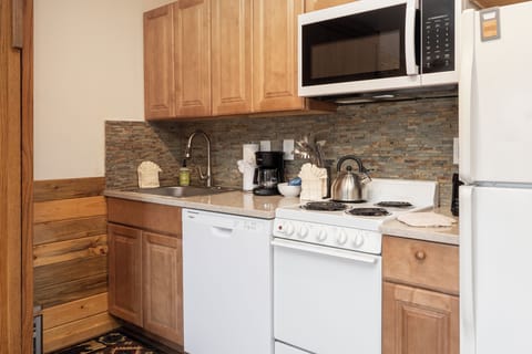 Your fully equipped kitchenette with granite counters, stone backsplash, and all appliances makes meal prep a pleasure during your stay.