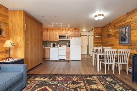 Your cozy cabin retreat blends rustic charm with modern comfort—warm wood walls, full kitchen, and dining space for memorable meals.