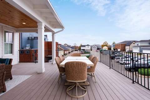 Enjoy meals with a view on this spacious deck, featuring a stylish wicker dining set and a view of the neighborhood. Perfect for gatherings or a quiet meal overlooking the community.