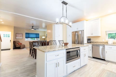 Entertain effortlessly in this expansive kitchen with an open floor plan. Enjoy granite countertops, a high-end gas stove, & ample storage. The kitchen flows seamlessly into the dining & living areas, perfect for gathering with family & friends