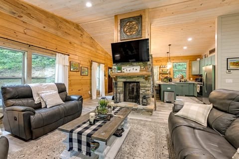 Cozy Living Room with sofa, loveseat, recliner, double-sided woodturning fireplace and smart TV.