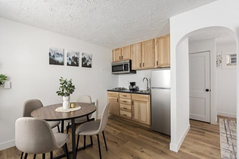 Functional kitchenette offering a dining table and wood-style cabinetry.