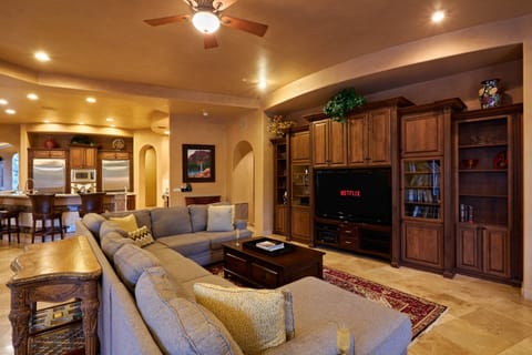 Bright open floor living space featuring a smart flat-screen TV, modern furnishings, and access to the outdoor patio.