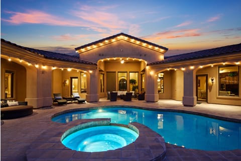 Outdoor oasis featuring a sparkling pool and hot tub. Multiple seating areas, lounge chairs, ping pong table, porch swing, outdoor grill with a built-in burner and mini-fridge, cornhole, putting green, and a gazebo.