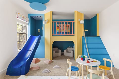 The custom-built playroom features a slide, games, and a craft table.