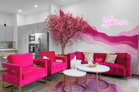 Stylish space w/ warm pink accents, playful details, and a cozy setup that feels bright, fun, and welcoming.