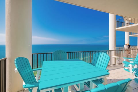 This balcony features bright turquoise furniture, perfect for enjoying stunning beachfront views and relaxing moments