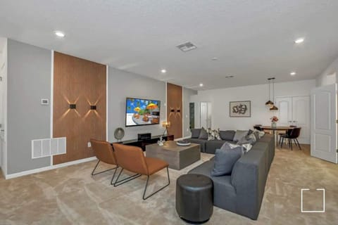 Relax in this spacious living room with a cozy sectional, modern decor, and ample seating, perfect for unwinding after a day of exploring.