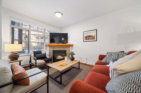 Spacious open-plan living area with a gas fireplace & sofa bed.