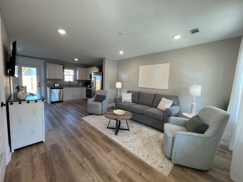 View of living area and kitchen from front entrance of home