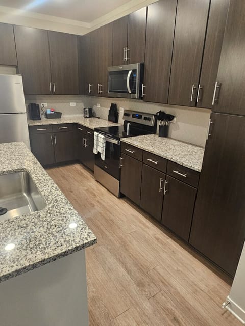 Stylish kitchen featuring premium finishes, spacious granite countertops, and full-size stainless steel appliances — ideal for extended stays.