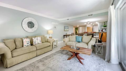 The spacious living room is anchored by comfortable tan sofas.