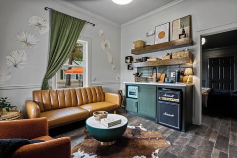 Separate living room with one of two full sofa sleepers and stocked tiny kitchen for light meal prep