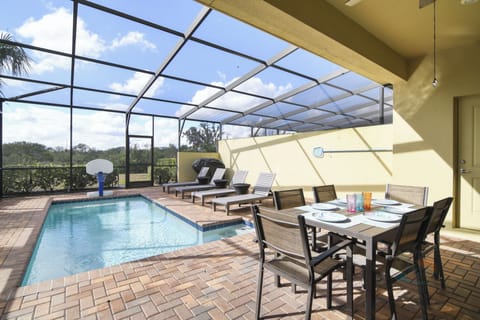 Screened pool patio with lounge chairs and dining area for outdoor relaxation.