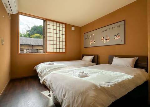 Bedroom with two single beds. A small refrigerator and microwave is provided.