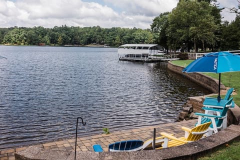 Chairs and umbrella by serene lake.